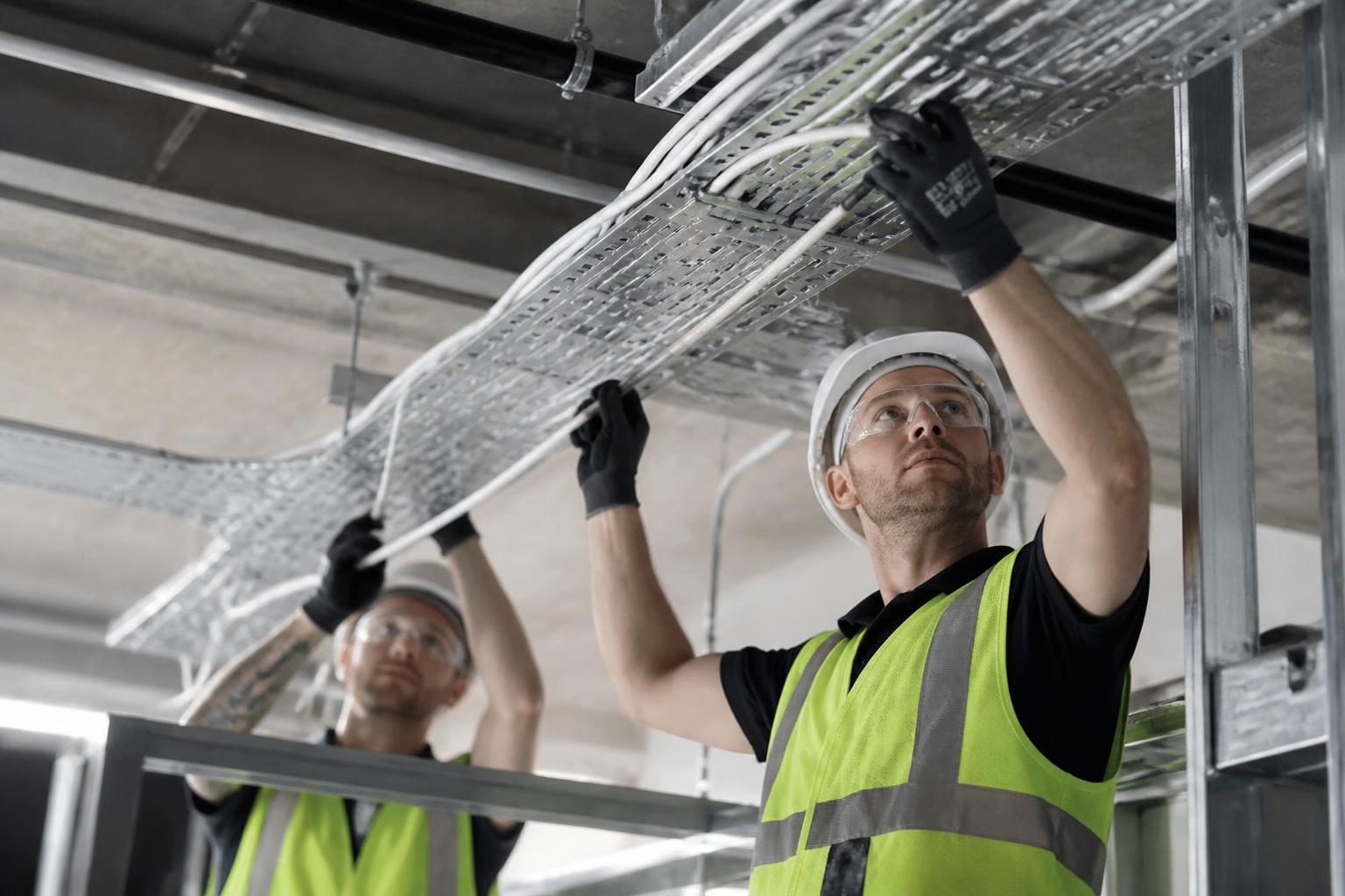 Electrical Contractors Insurance 2 Electricians running cable trays in a modern commercial building fit out
