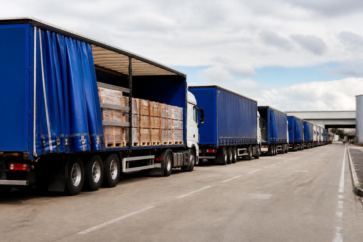 HGV, Haulage and Logistics Insurance 2 Curtain-sided articulated lorries lined up at a UK logistics hub
