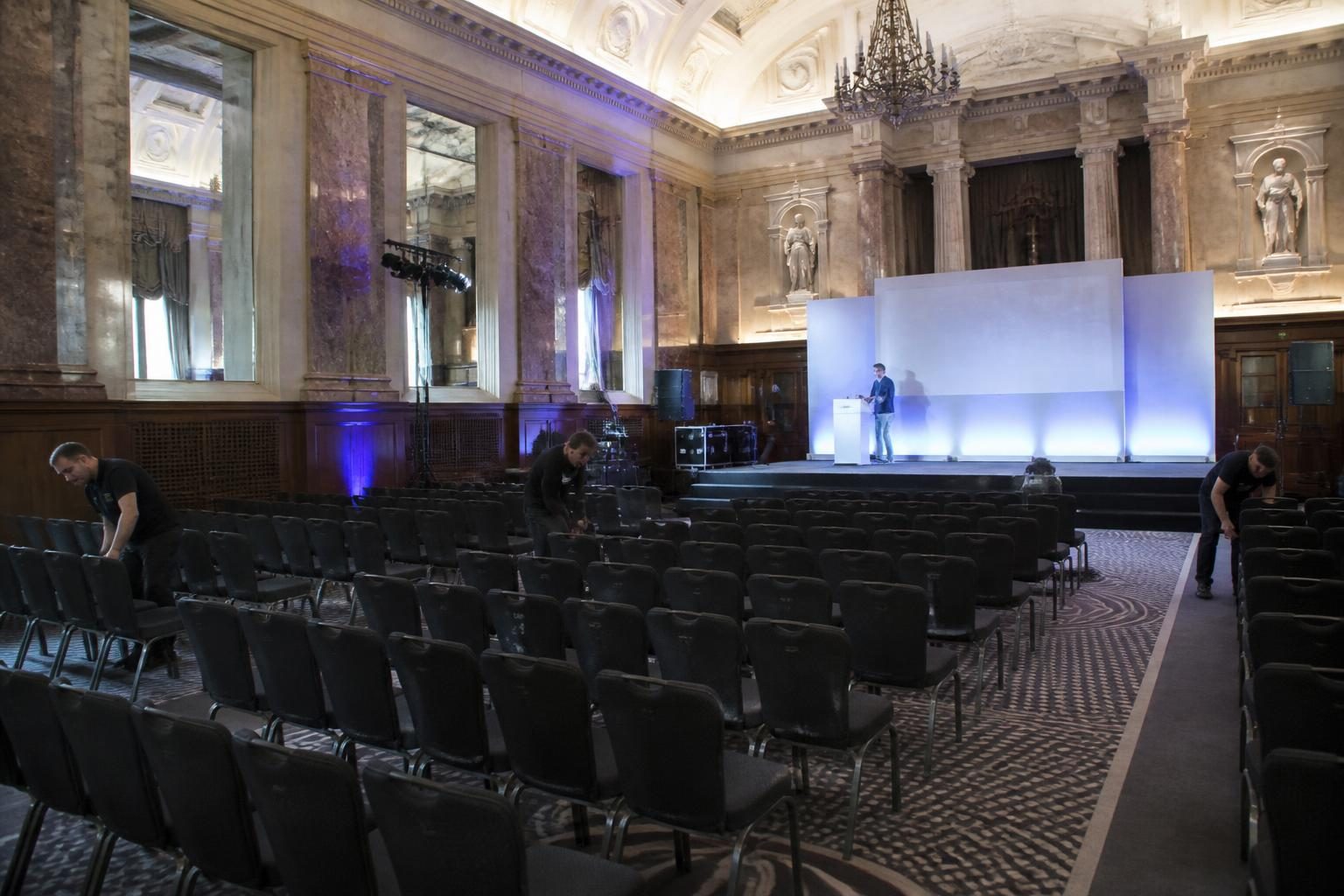 A UK events venue being set up for a conference with staging and seating