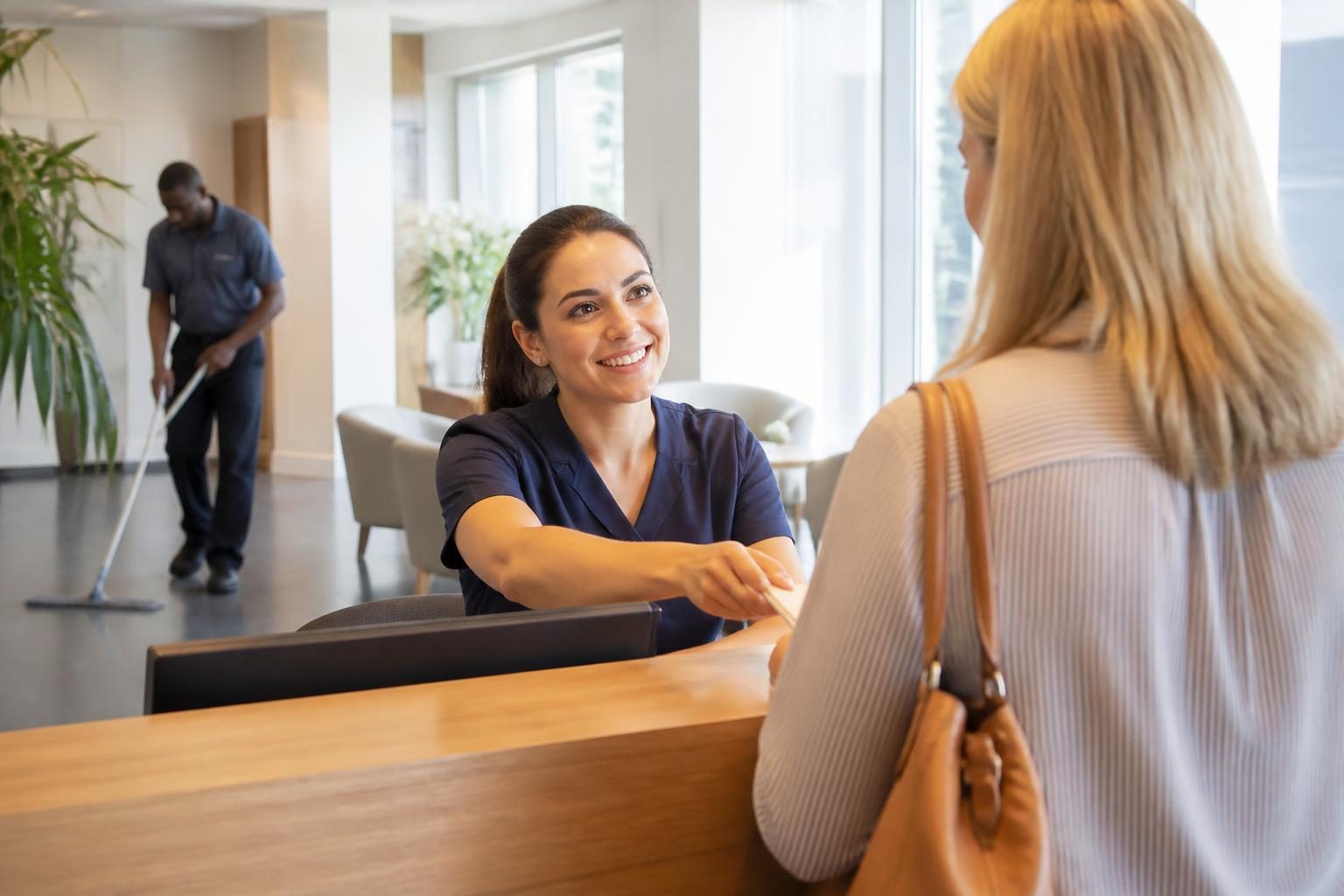 Reception team greeting a client at a UK healthcare business